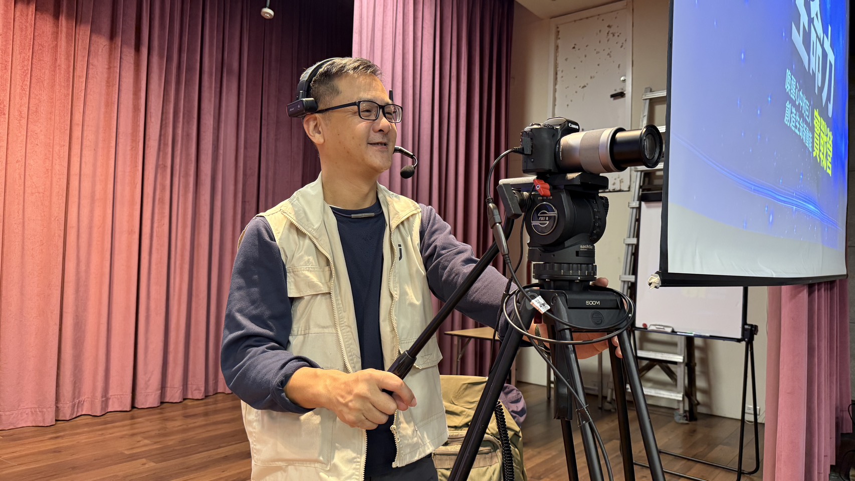 Jeanine White smiling in a red plaid shirt and tortoise shell glasses